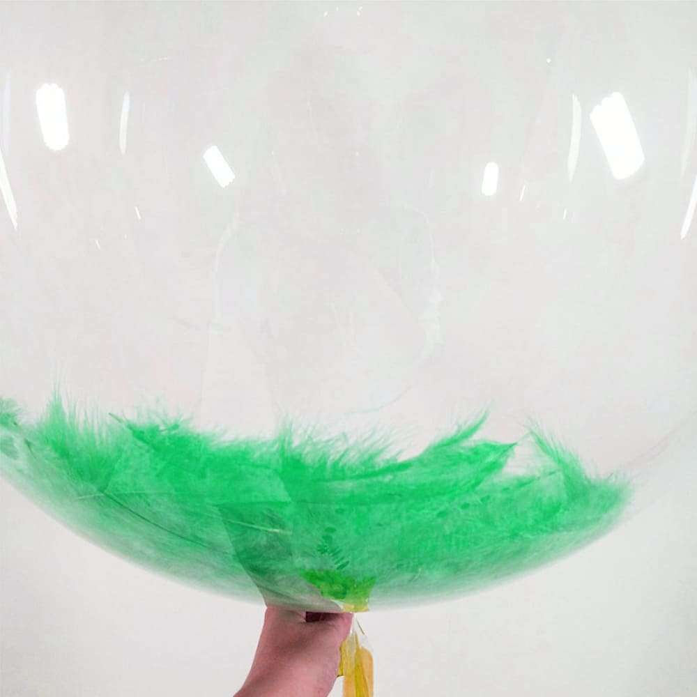 Прозрачный шарик с зелёными перьями картинка